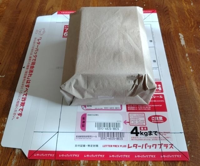 レターパックプラスの封筒の上に今回入れる予定の箱を置いた画像｜計算上は入るはずであることを示唆