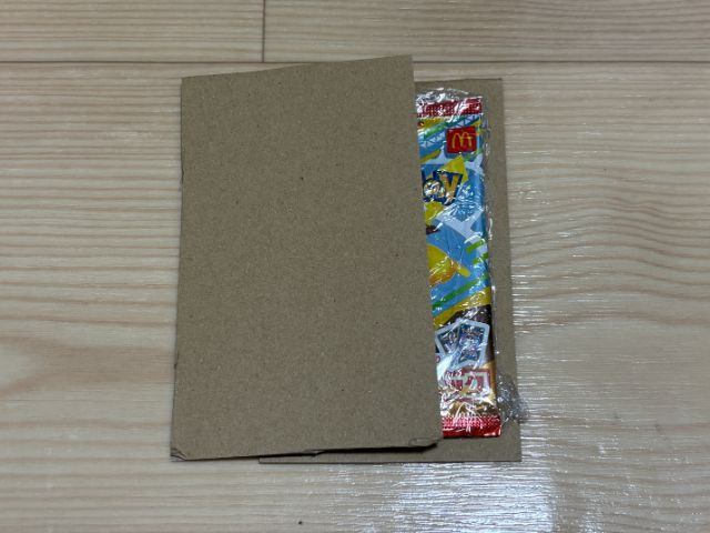 さらにダンボールや厚紙で両面から挟み、テープで固定しましょう。