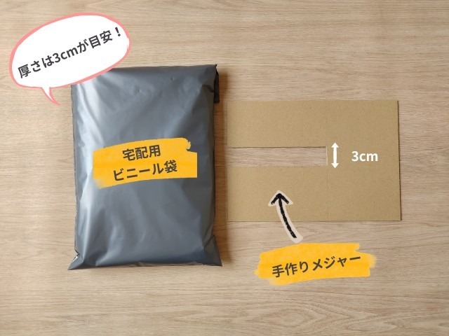 OPP袋に入れた洋服を、宅配用ビニール袋に入れたもの(左側)と、厚さ3センチの幅に切り込みを入れたダンボールの簡易メジャー(右側)の写真
